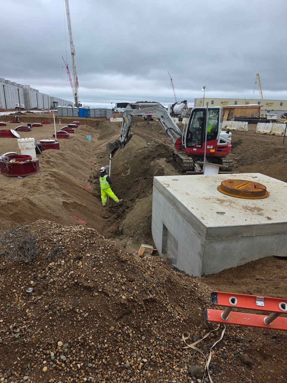 Commercial sitework with a mini excavator and concrete utility vaults