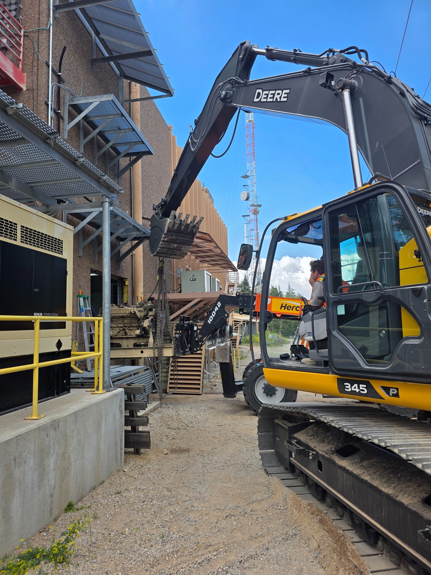 Excavator supporting industrial equipment installation