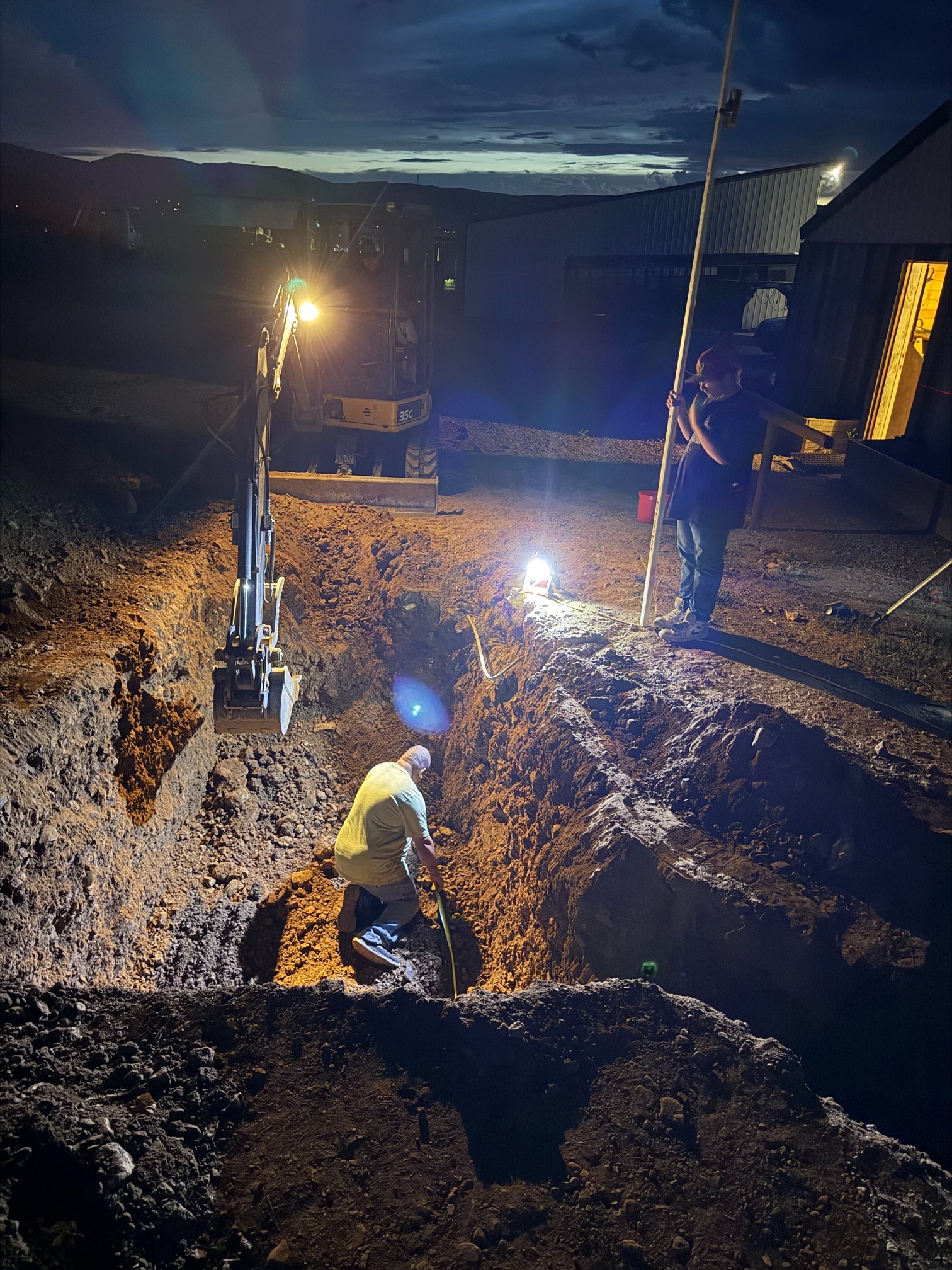 Excavation crew completing septic work after dark