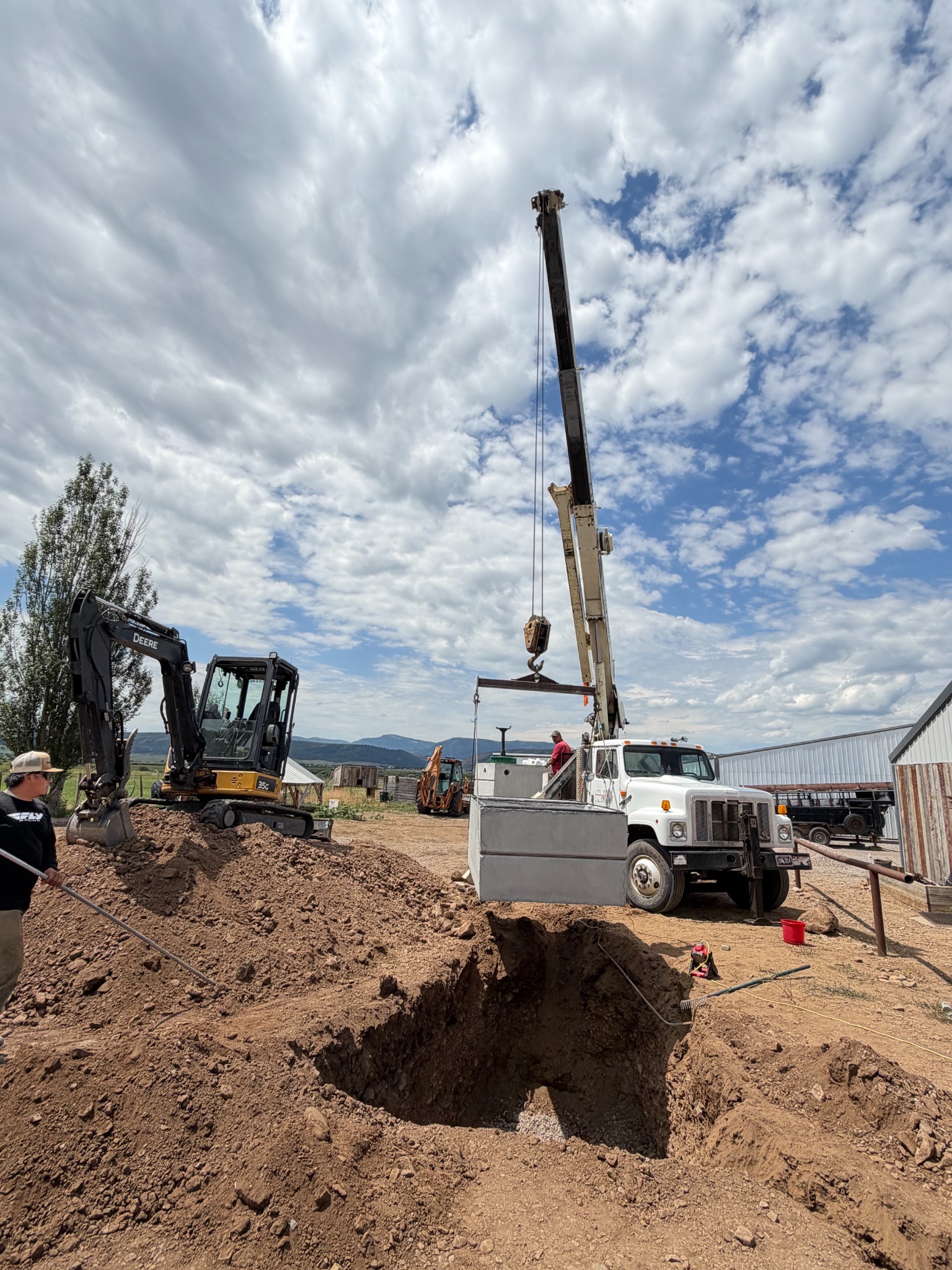 Crew and crane installing a septic tank